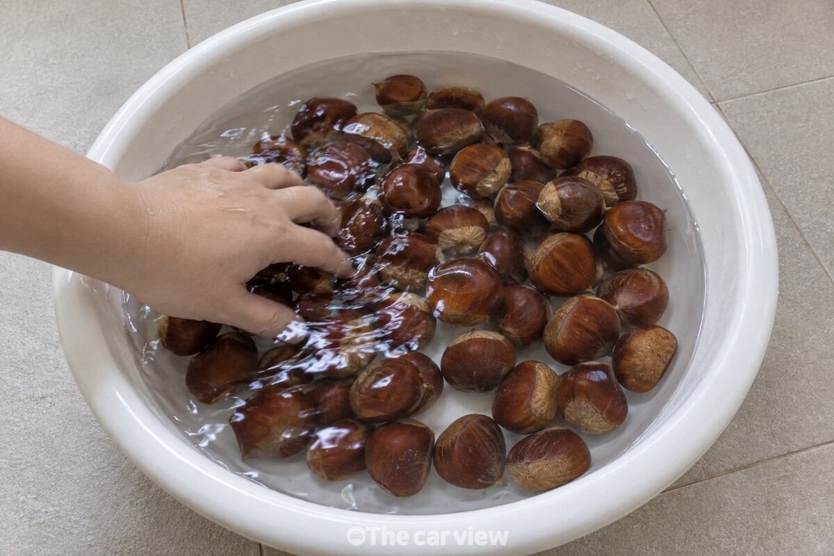 큰 흰 대야에 찬물을 넉넉히 받고 손으로 밤을 한 번 휘젓는 모습이다. / 기사 이해를 돕기 위한 생성형 이미지