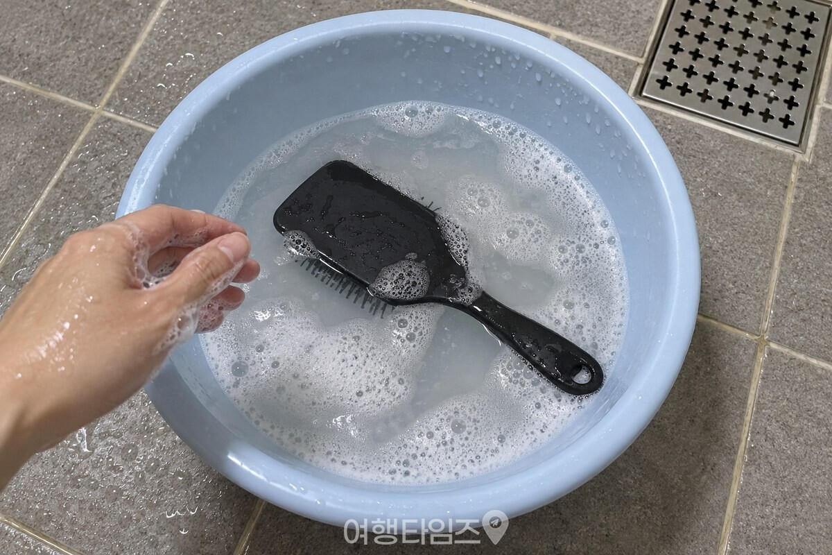 손으로 거품을 낸 따뜻한 물에 검은 플라스틱 빗을 빗살이 아래로 향하게 담가 두었다. / 기사 이해를 돕기 위한 생성형 이미지