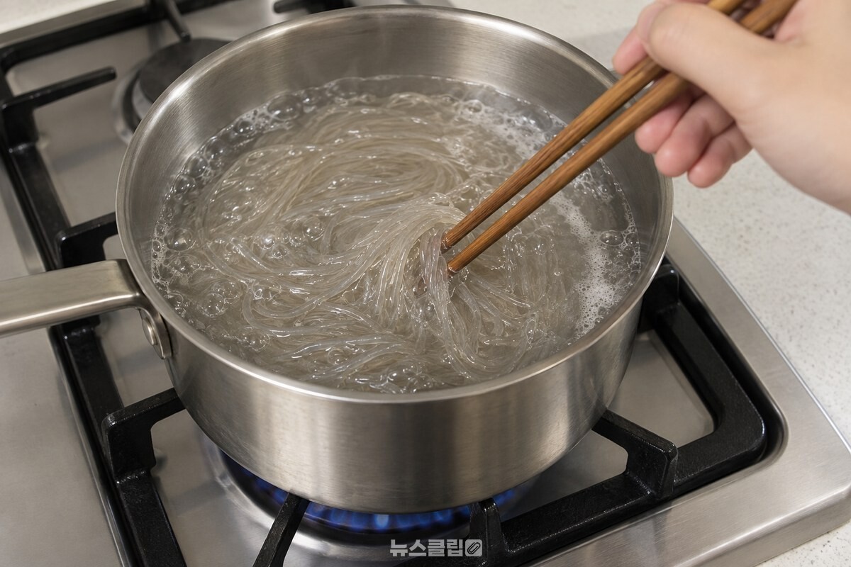 불린 당면을 삶는 냄비에서 젓가락으로 가볍게 저어 주는 모습. / 기사 이해를 돕기 위한 생성형 이미지
