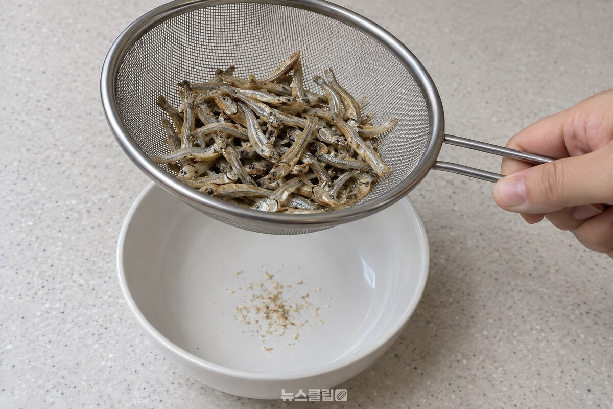 기름 없이 볶은 잔멸치를 체에 담아 가루를 털어 내는 모습입니다. / 기사 이해를 돕기 위한 생성형 이미지