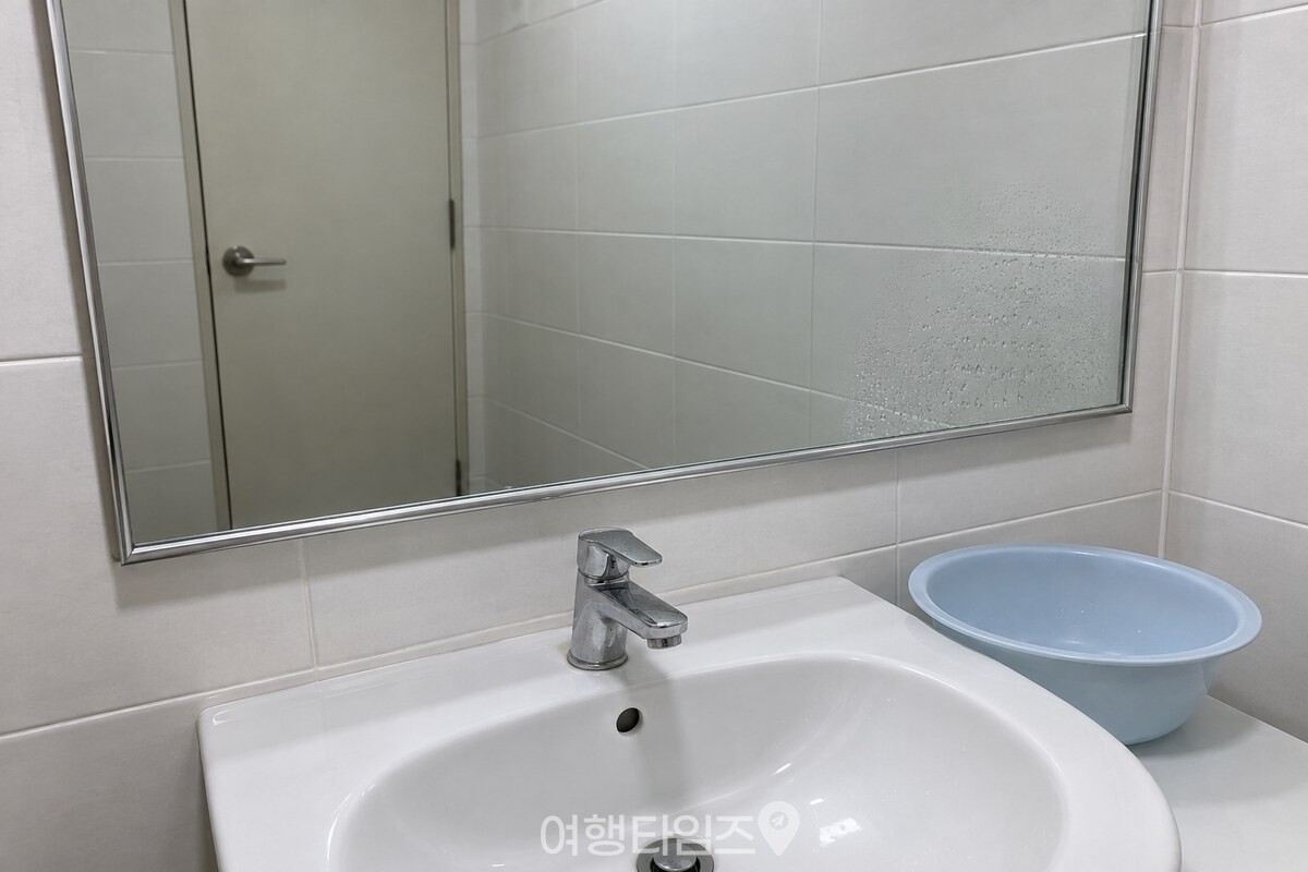 샤워 직후 거울 한쪽에만 작은 물방울이 맺히고 나머지 세면대 주변은 정돈된 욕실 모습. / 기사 이해를 돕기 위한 생성형 이미지