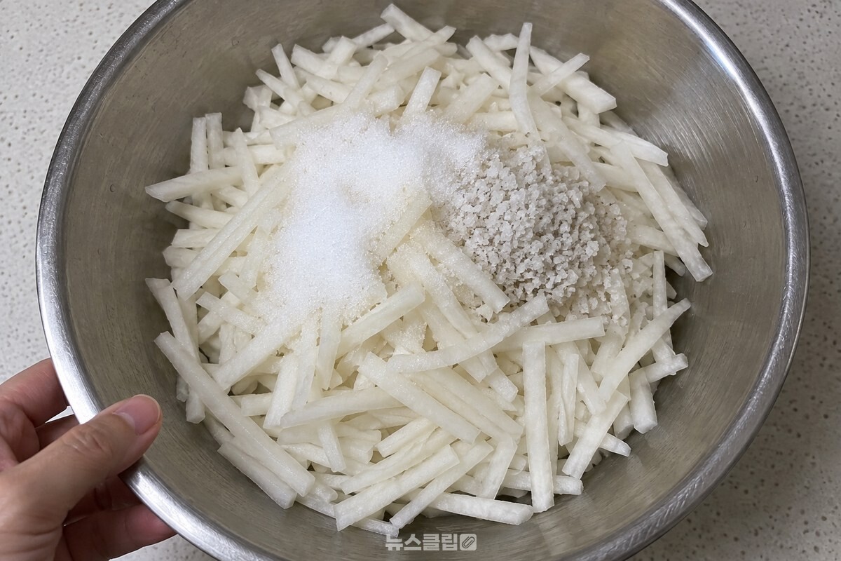 큰 스테인리스 볼에 0.5센티미터 굵기로 썬 무채와 설탕, 천일염이 담겨 있다. / 기사 이해를 돕기 위한 생성형 이미지