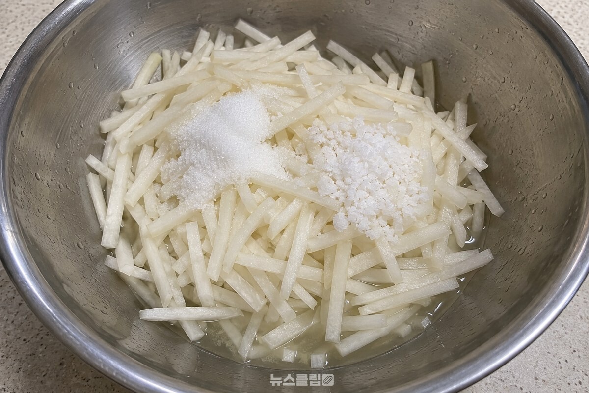 설탕과 천일염을 뿌린 채 썬 무 아래에 맑은 절임물이 조금 고여 있다. / 기사 이해를 돕기 위한 생성형 이미지