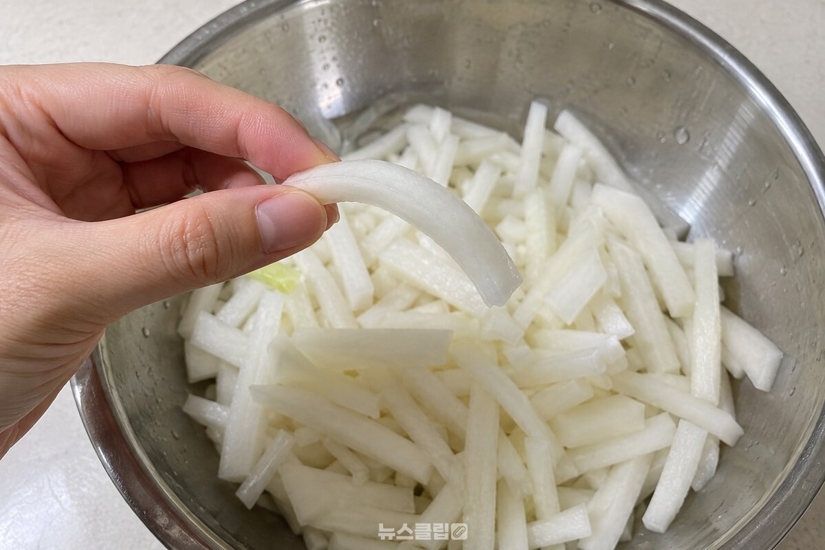 깨끗한 손가락으로 집은 무채 한 가닥이 부드럽게 휘어 있다. / 기사 이해를 돕기 위한 생성형 이미지