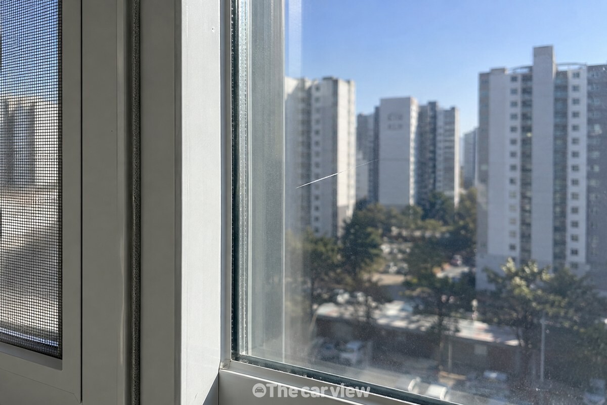 직사광선이 닿는 거실 유리창 한쪽에만 옅은 흰 줄이 보이는 근접 장면. / 기사 이해를 돕기 위한 생성형 이미지