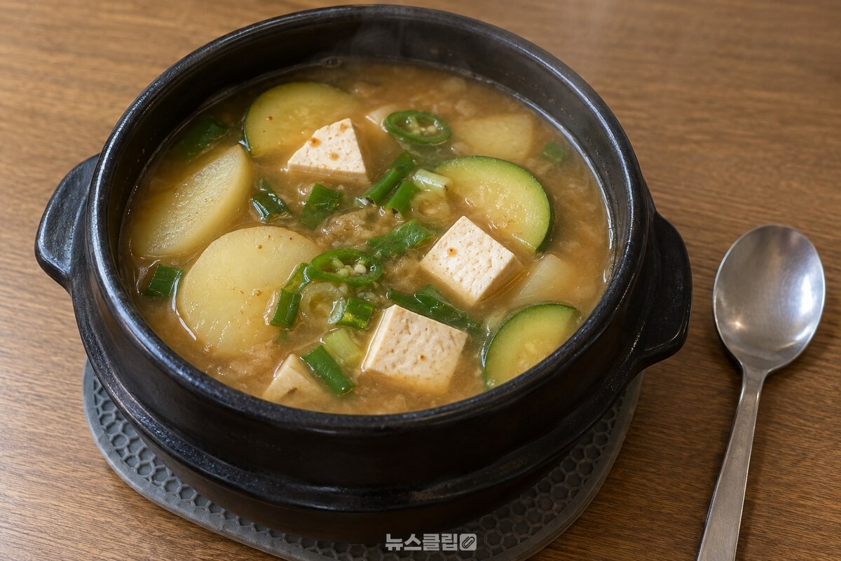 감자와 애호박, 두부가 담긴 된장찌개가 한국 가정의 식탁 위 냄비에 담겨 있다. / 기사 이해를 돕기 위한 생성형 이미지