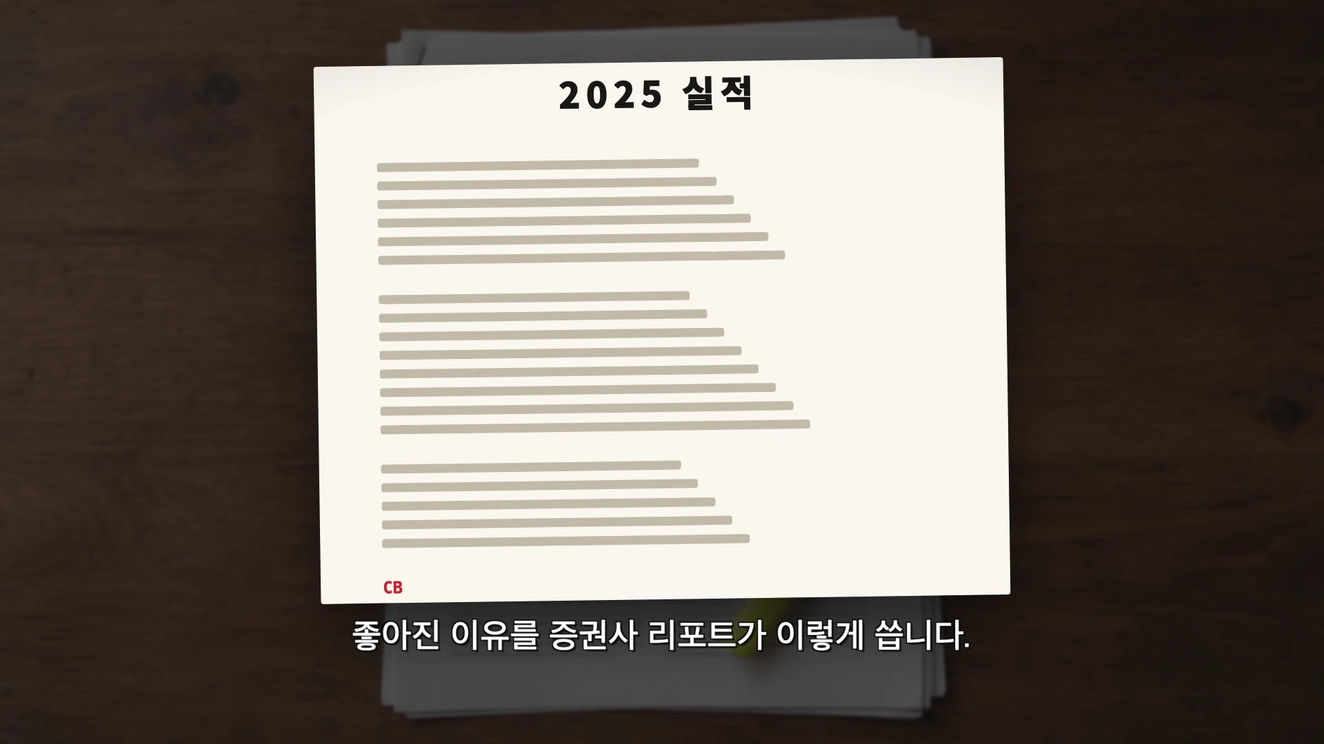 2025 실적이라는 제목이 적힌 문서가 나무 책상 위에 놓여 있는 모습.