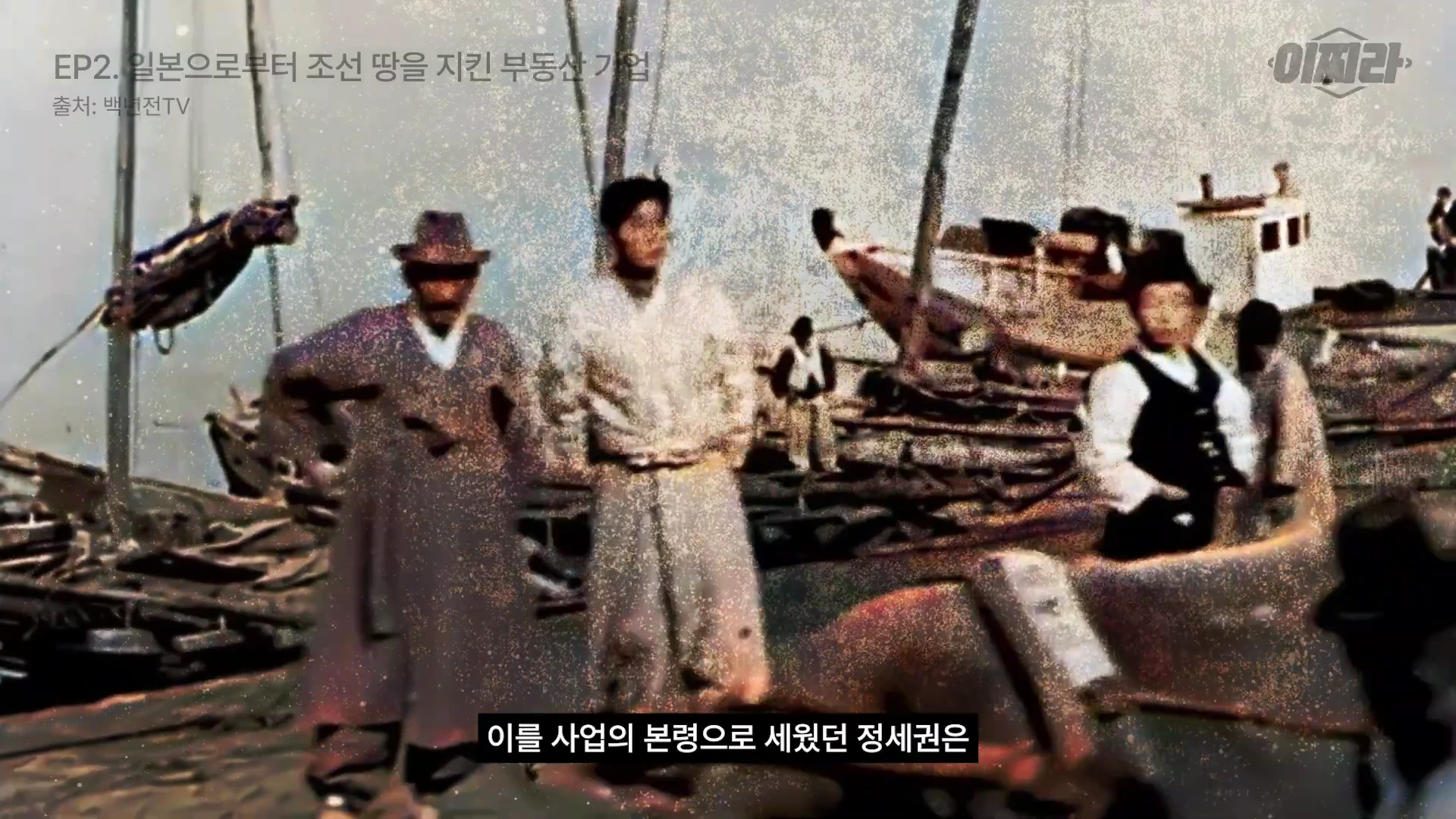 일제강점기 당시 항구 배경으로 한복을 입은 사람들이 서 있는 흑백 사진이 영상 화면에 보임