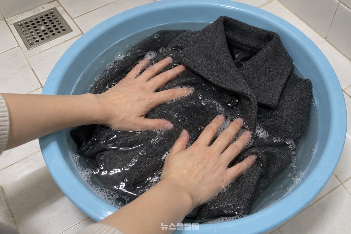 찬물을 받은 대야에서 중성세제를 푼 물에 울코트를 손바닥으로 가볍게 누르는 모습. / 기사 이해를 돕기 위한 생성형 이미지
