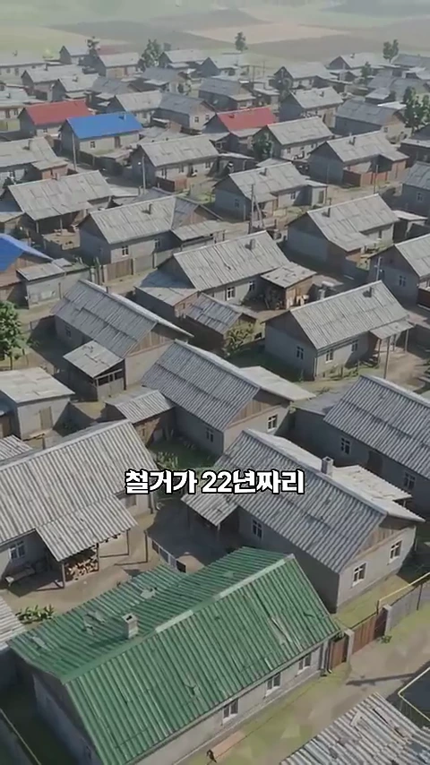 많은 주택이 밀집해 있는 마을의 높은 곳에서 내려다본 항공 사진이며, '철거가 22년짜리'라는 자막이 중앙에 적혀 있습니다.