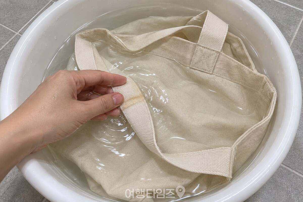 깨끗한 대야 안에서 손가락으로 에코백 손잡이의 한 부분을 가볍게 문지르고 있다. / 기사 이해를 돕기 위한 생성형 이미지
