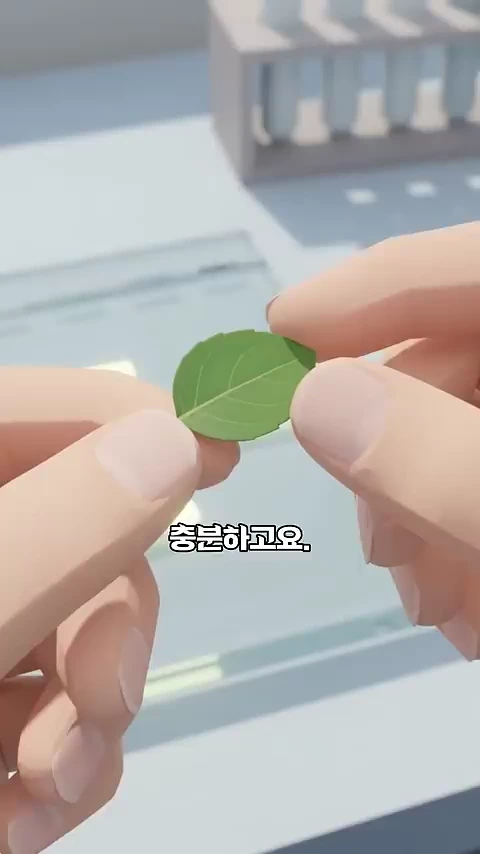 손가락으로 작은 녹색 나뭇잎 한 장을 들고 있는 모습의 3D 애니메이션 장면입니다.