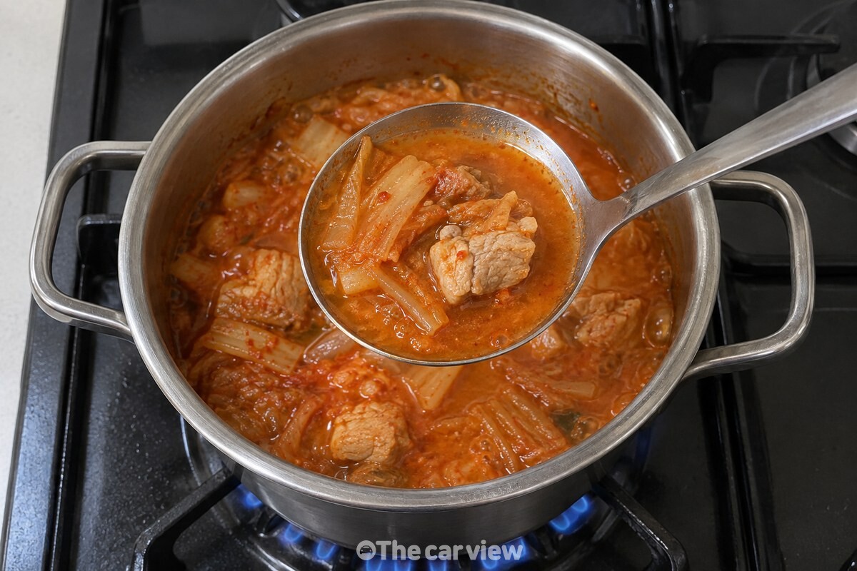 쌀뜨물을 넣어 끓인 김치찌개 국물이 국자에 담겨 농도를 보여 준다. / 기사 이해를 돕기 위한 생성형 이미지