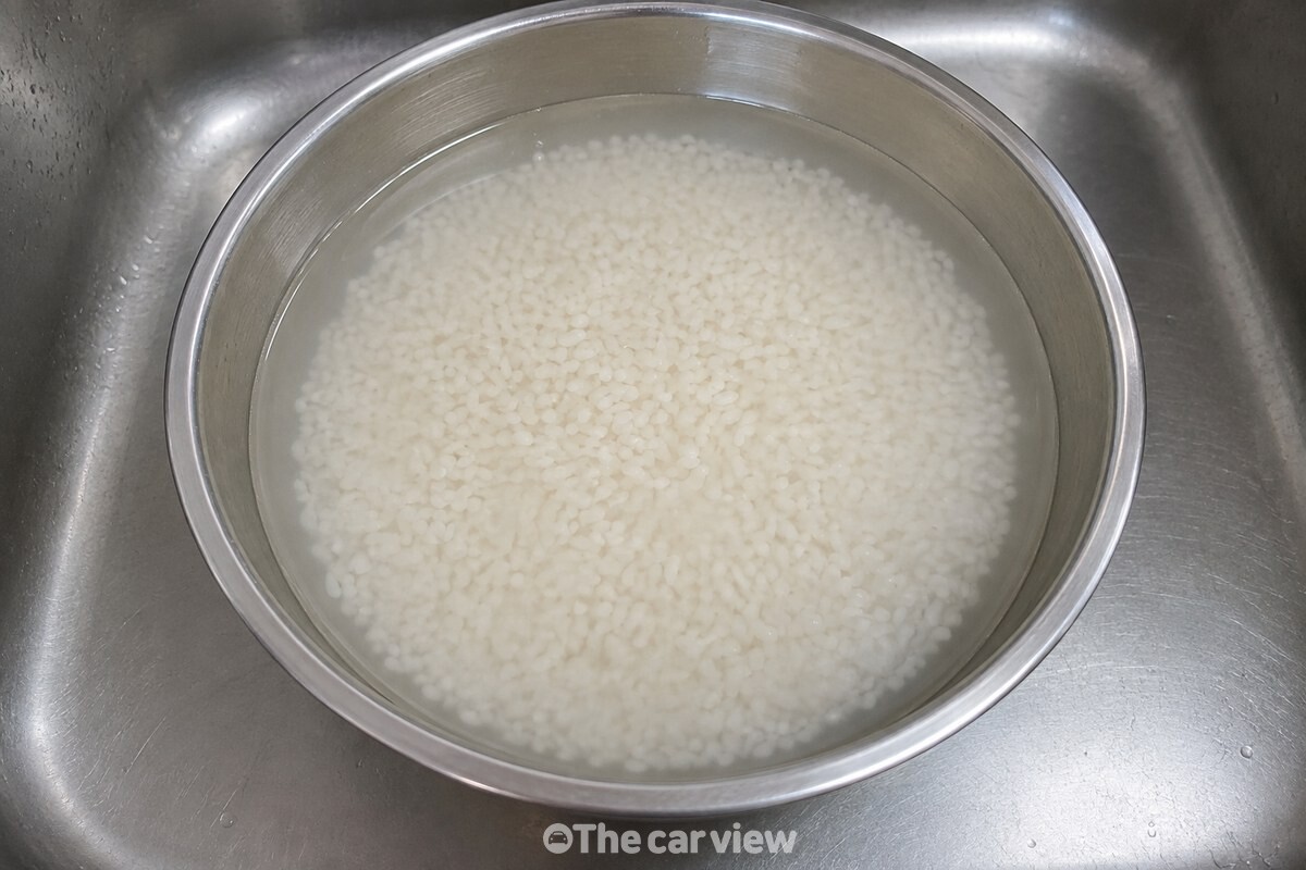 첫 물을 받은 쌀알 주위로 물이 옅게 뿌옇게 보이는 가까운 모습. / 기사 이해를 돕기 위한 생성형 이미지