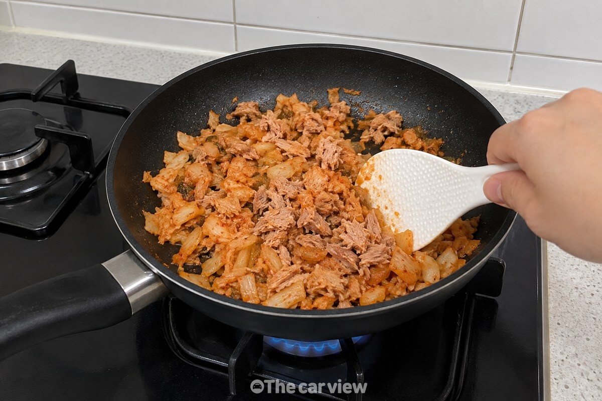 잘게 썬 김치와 참치를 팬에서 먼저 볶는 모습. / 기사 이해를 돕기 위한 생성형 이미지