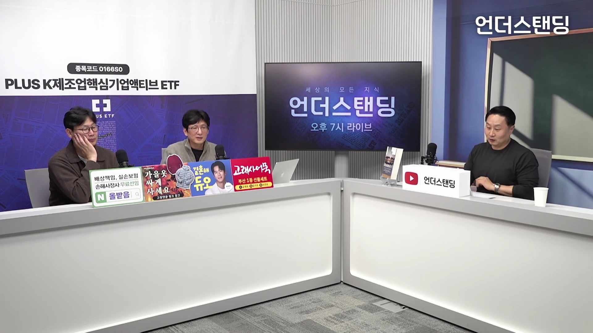 스튜디오에 세 명의 남성이 책상 앞에 앉아 대화를 나누고 있는 모습으로, 벽면에는 '언더스탠딩' 로고와 함께 뉴스 형식의 화면이 보입니다.