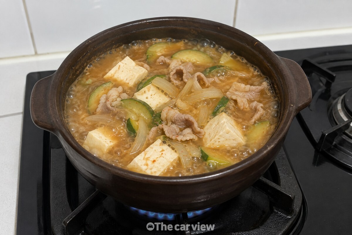 끓는 된장찌개에 두부, 대패삼겹살, 양파와 호박이 익어 가고 있다. / 기사 이해를 돕기 위한 생성형 이미지
