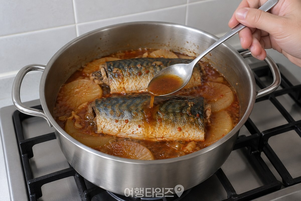 껍질이 위로 향한 고등어에 냄비 국물을 숟가락으로 끼얹고 있습니다. / 기사 이해를 돕기 위한 생성형 이미지