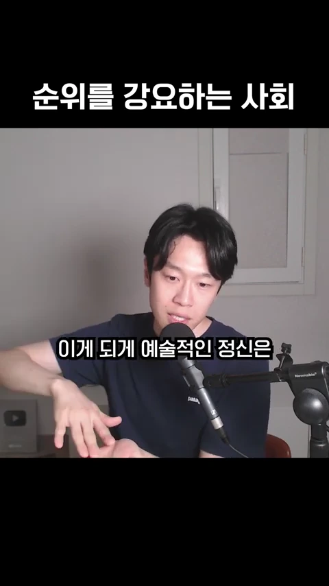 마이크 앞에 앉아 손동작을 하며 이야기하는 남성의 모습이 담긴 영상 캡처 화면이며 화면 상단에 '순위를 강요하는 사회'라는 자막이, 중앙에는 '이게 되게 예술적인 정신은'이라는 자막이 표시되어 있습니다.