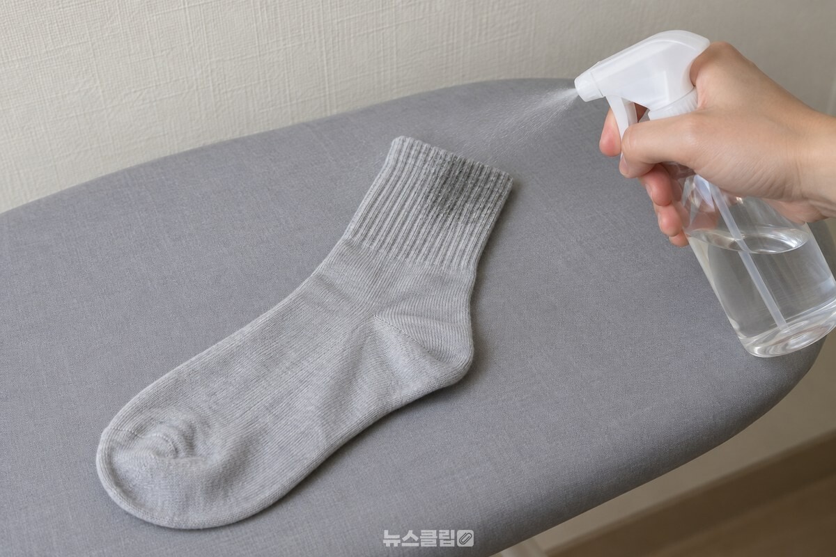 다리미판에 편 양말 목 부분에 희석액을 고르게 뿌리는 손. / 기사 이해를 돕기 위한 생성형 이미지
