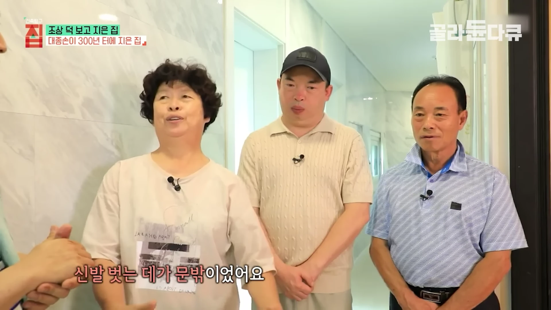 실내에서 인터뷰하는 중년 여성과 두 남성의 모습.