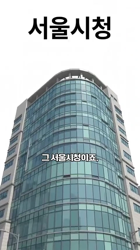 서울시청 새 청사 건물의 외관이 아래에서 위로 올려다보는 각도로 촬영되어 있으며, 건물 중앙에 '서울시청', '그 서울시청이죠.'라는 한글 자막이 배치되어 있습니다.