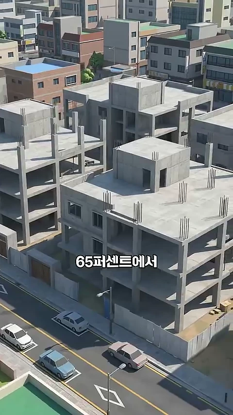 공사 중단으로 인해 회색 콘크리트 골조만 남은 다세대 주택 단지와 그 앞을 지나는 도로 위의 자동차들.