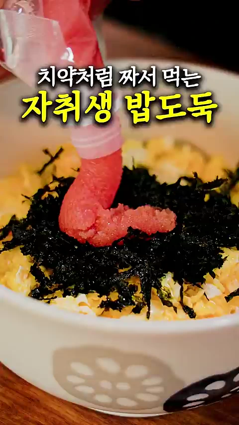 튜브에서 붉은 명란젓이 김가루와 계란이 담긴 그릇 위로 짜이고 있으며 그 위에 '치약처럼 짜서 먹는 자취생 밥도둑'이라는 문구가 적혀 있습니다.