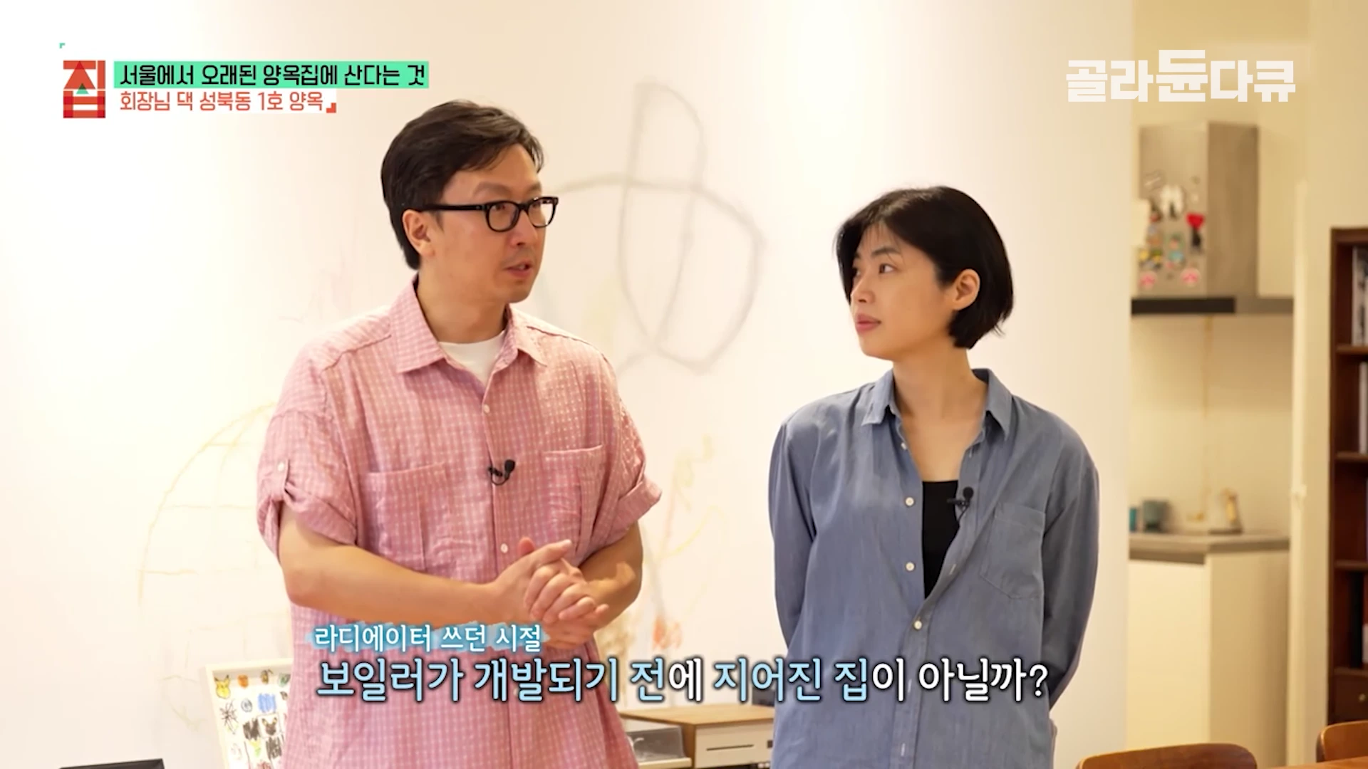 실내에서 분홍색 체크무늬 셔츠를 입은 남성과 푸른색 셔츠를 입은 여성이 서서 대화를 나누고 있는 모습으로, 화면 하단에는 라디에이터 시절에 대한 자막이 적혀 있다.