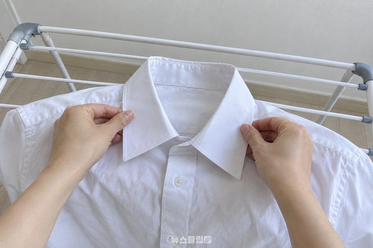 깨끗한 흰색 와이셔츠의 깃을 양손으로 평평하게 펴는 모습. / 기사 이해를 돕기 위한 생성형 이미지