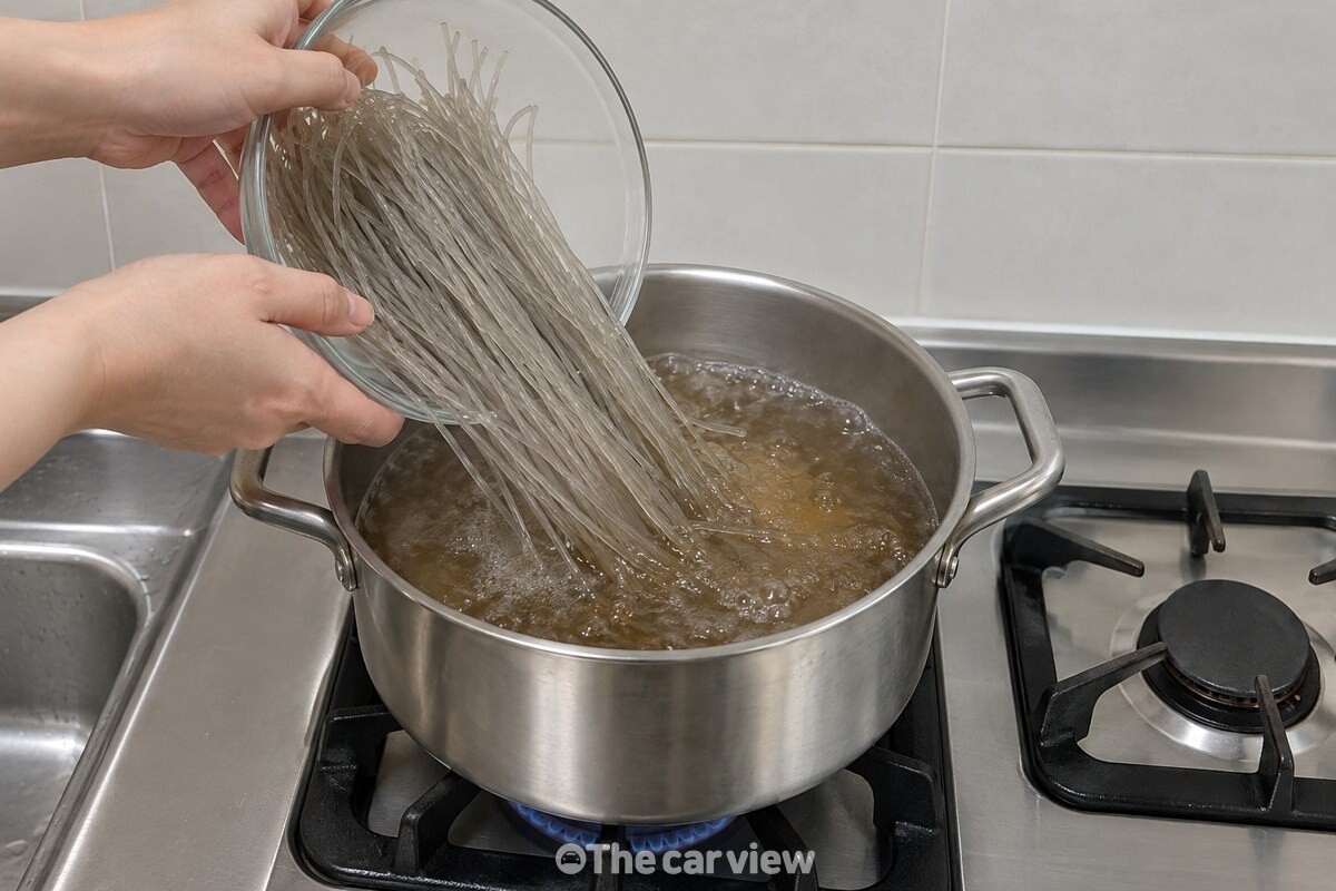 간장과 흑설탕을 넣은 다시마물이 끓는 냄비에 마른 잡채 당면을 펼쳐 넣는 모습. / 기사 이해를 돕기 위한 생성형 이미지
