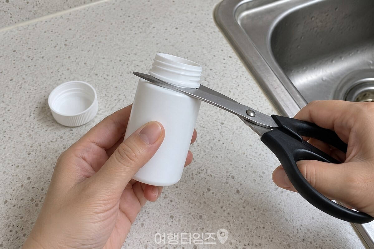 깨끗이 씻어 말린 빈 약통의 주둥이 부분을 가위로 자르기 전 손으로 잡고 있다. / 기사 이해를 돕기 위한 생성형 이미지