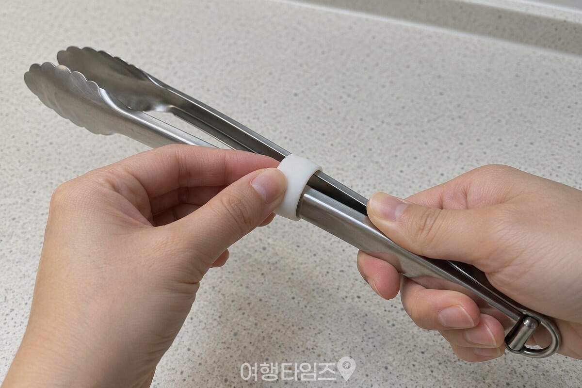 손으로 모은 주방 집게 손잡이 끝에 짧은 흰색 플라스틱 링을 밀어 끼우고 있다. / 기사 이해를 돕기 위한 생성형 이미지