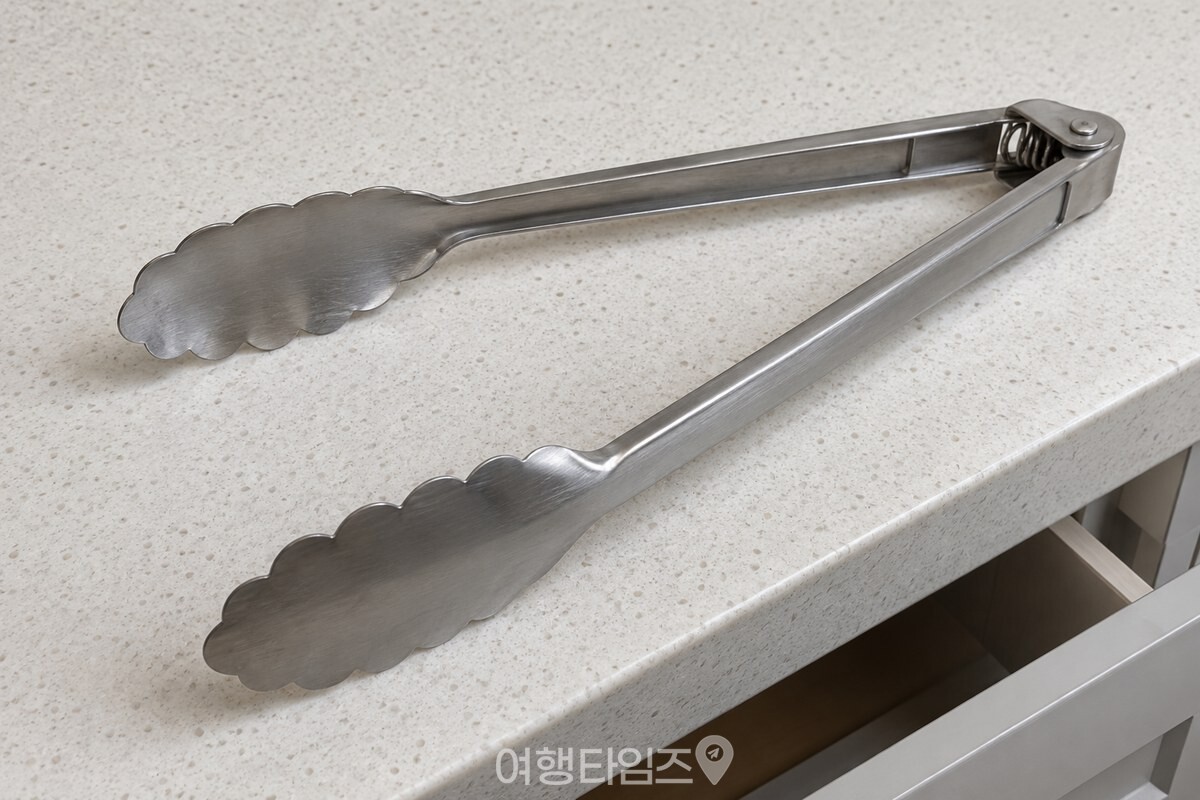 손을 놓은 스테인리스 주방 집게의 두 날과 손잡이가 스프링 힘으로 벌어진 모습이다. / 기사 이해를 돕기 위한 생성형 이미지
