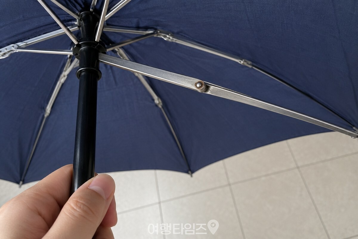 펼친 우산 안쪽에서 우산대와 우산살을 잇는 작은 금속 관절을 가까이 담은 모습. / 기사 이해를 돕기 위한 생성형 이미지