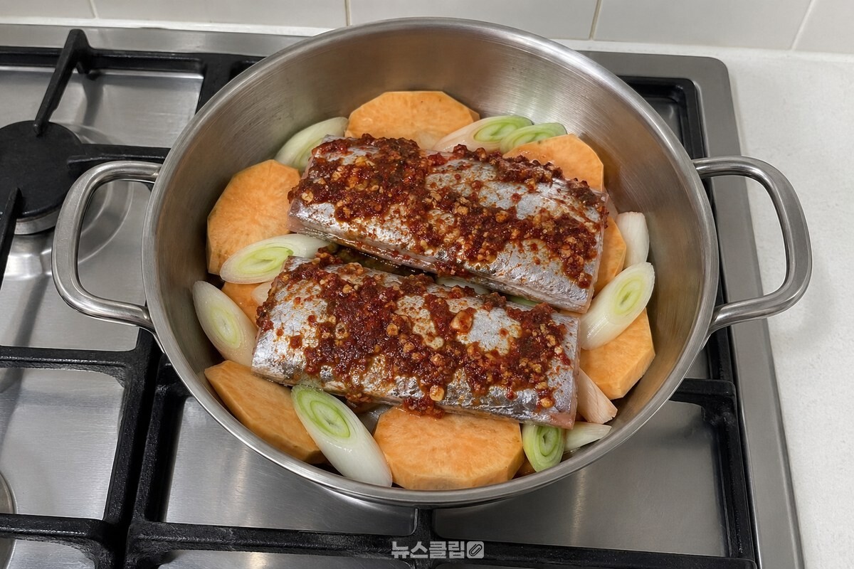 냄비 바닥에 고구마와 대파를 한 겹으로 깔고 갈치를 올린 모습. / 기사 이해를 돕기 위한 생성형 이미지