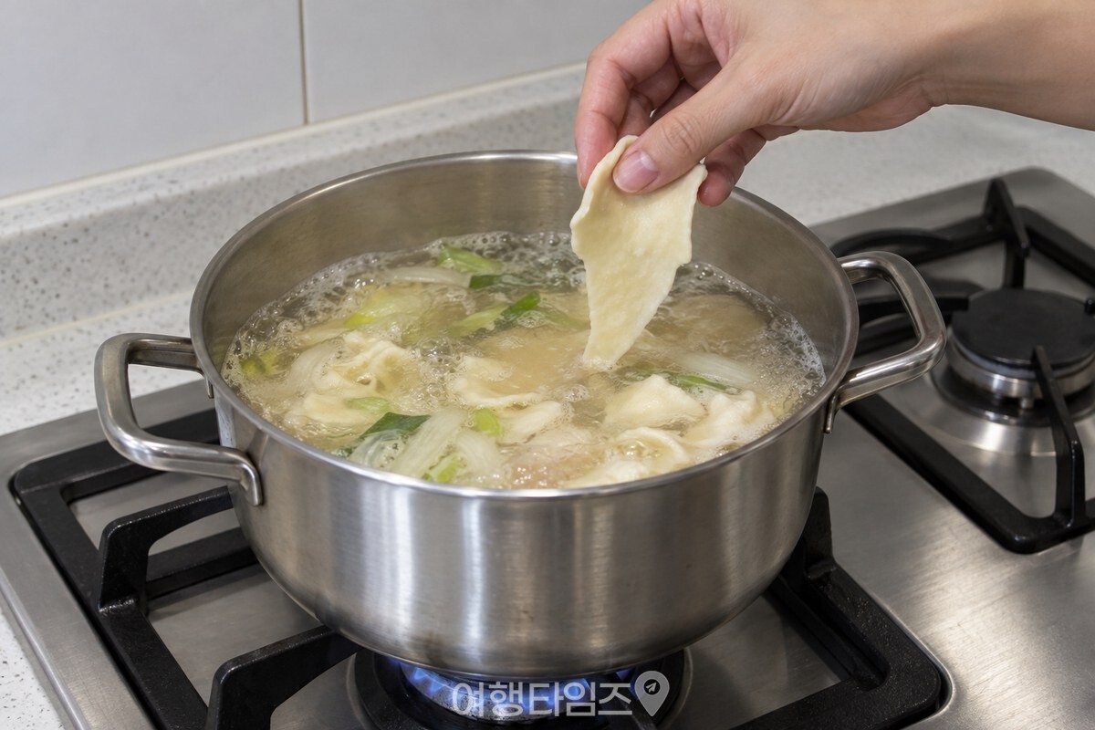 끓는 국물 냄비 가장자리에서 얇게 늘린 반죽을 떼어 넣는 손 / 기사 이해를 돕기 위한 생성형 이미지