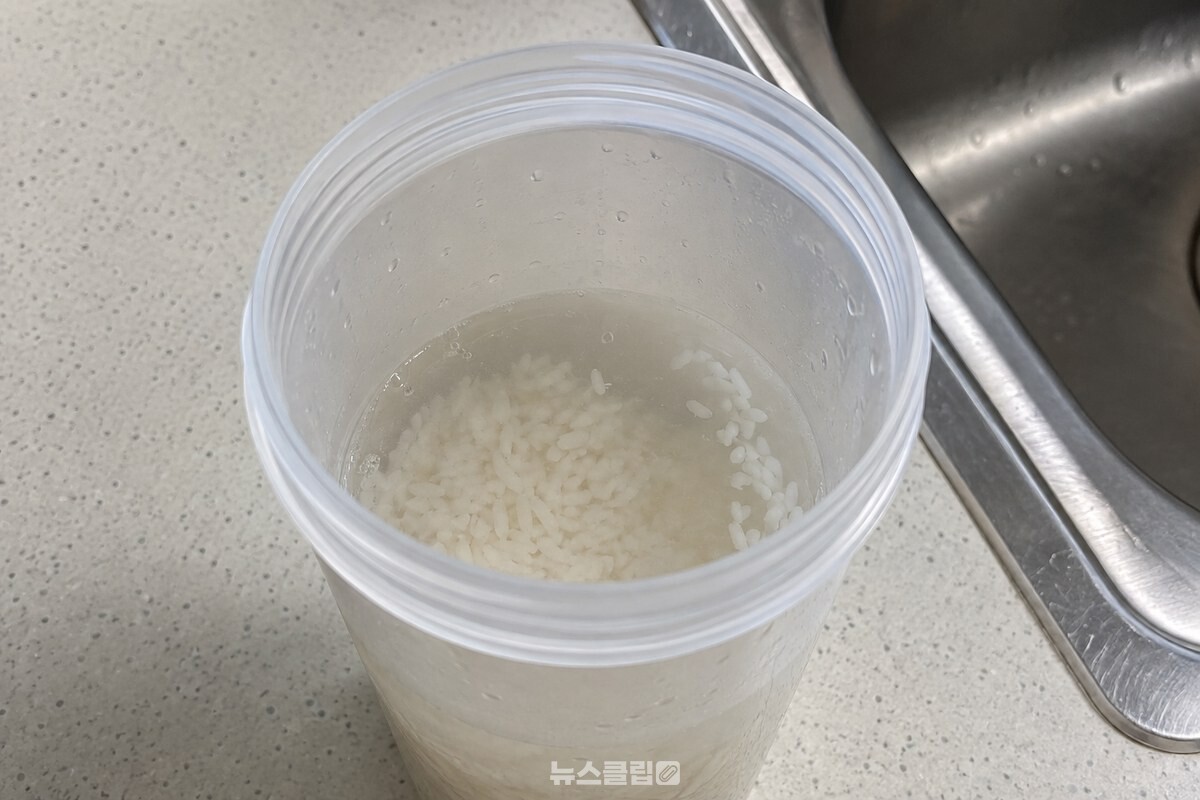 따뜻한 물 속에서 밥알이 풀리기 시작한 투명 플라스틱 텀블러의 안쪽. / 기사 이해를 돕기 위한 생성형 이미지