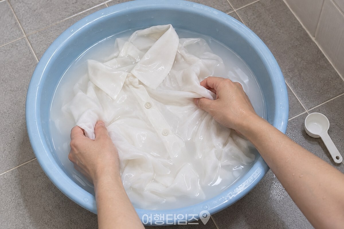 찬물에 우유를 섞은 대야에서 흰 실크 블라우스를 가볍게 흔들어 헹구는 모습 / 기사 이해를 돕기 위한 생성형 이미지