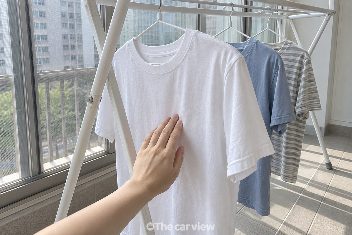 실내 건조대에 넌 얇은 반팔 옷감에 손등을 대어 보는 모습. / 기사 이해를 돕기 위한 생성형 이미지