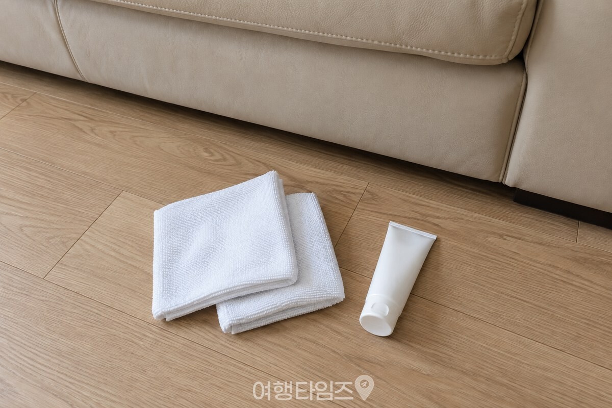 무색 핸드크림과 마른 천 두 장을 소파 앞 바닥에 준비한 모습이다. / 기사 이해를 돕기 위한 생성형 이미지