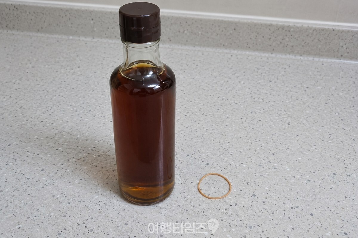 좁은 참기름병 병목 옆에 지름이 작은 얇은 사무용 고무줄을 놓은 모습. / 기사 이해를 돕기 위한 생성형 이미지