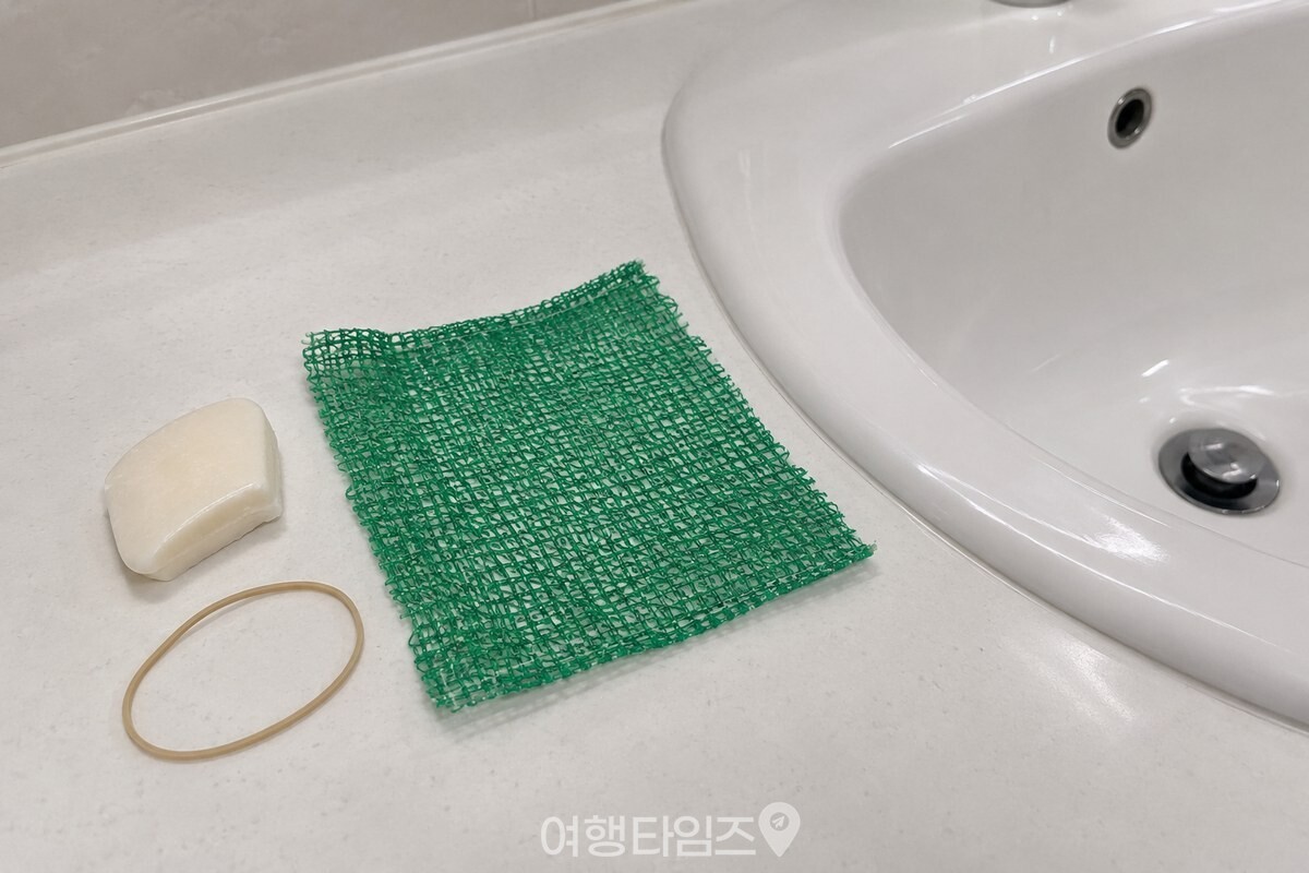 세면대 옆에 놓인 작은 비누 조각과 잘라 놓은 때타월, 고무줄을 가까이에서 담은 모습. / 기사 이해를 돕기 위한 생성형 이미지