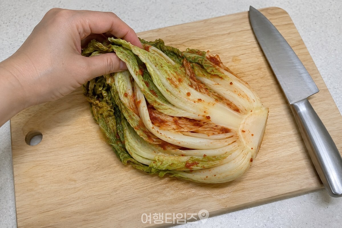 양념소를 가볍게 털어 낸 묵은지 한 켜를 도마 위에서 손질하고 있다. / 기사 이해를 돕기 위한 생성형 이미지