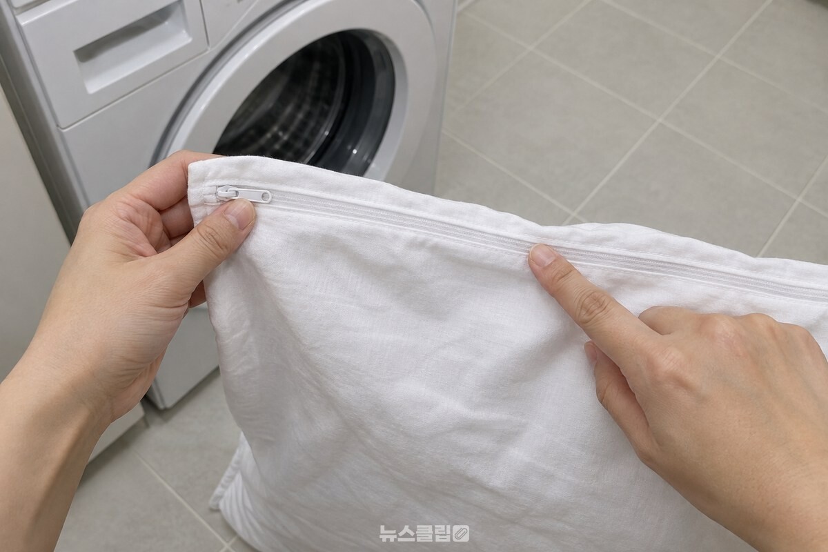 흰 베개커버의 지퍼를 끝까지 닫아 손가락으로 지퍼 줄을 확인하는 모습. / 기사 이해를 돕기 위한 생성형 이미지