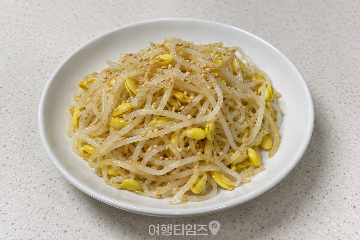 흰 접시에 담긴 콩나물무침 위로 통깨가 고르게 뿌려져 있다. / 기사 이해를 돕기 위한 생성형 이미지