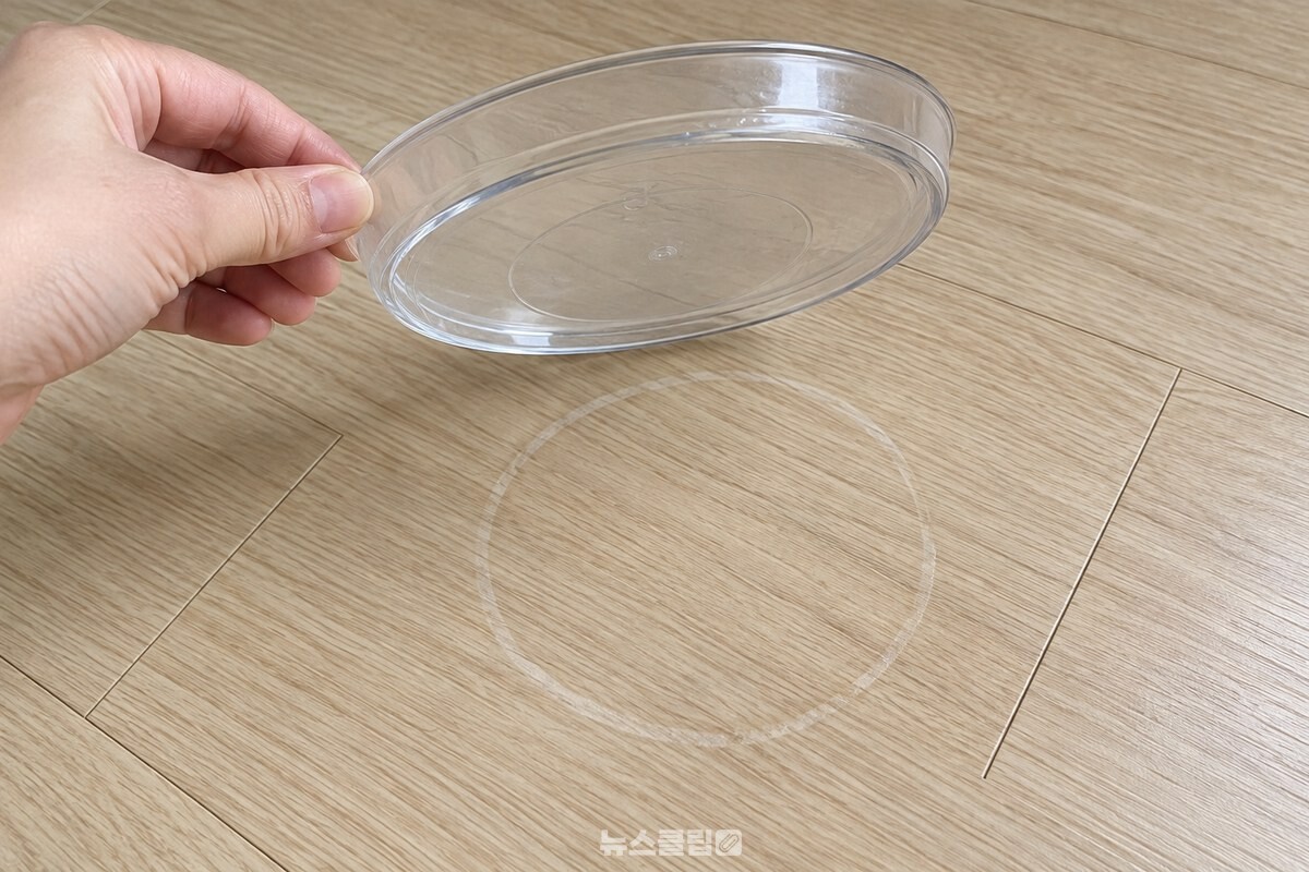받침을 들어 올린 깨끗한 장판 위에 남은 옅은 물기 테두리. / 기사 이해를 돕기 위한 생성형 이미지