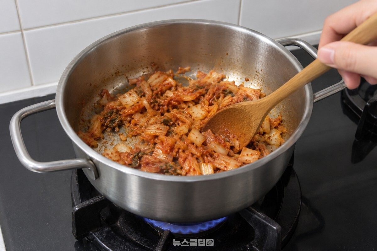 물기를 짠 묵은지를 참기름 두른 냄비에서 볶는 모습. / 기사 이해를 돕기 위한 생성형 이미지