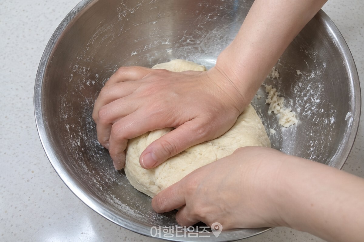 연한 베이지색 반죽을 손으로 한 덩어리로 눌러 뭉치는 과정. / 기사 이해를 돕기 위한 생성형 이미지
