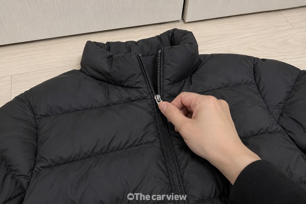 립밤을 바른 검은 패딩 지퍼 손잡이를 천천히 올리는 모습 / 기사 이해를 돕기 위한 생성형 이미지